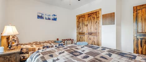 Ein Schlafzimmer mit einem großen Bett, einem Deckenventilator und Holztüren.