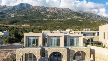 A modern building with multiple levels, large glass windows, and a stone archway entrance.