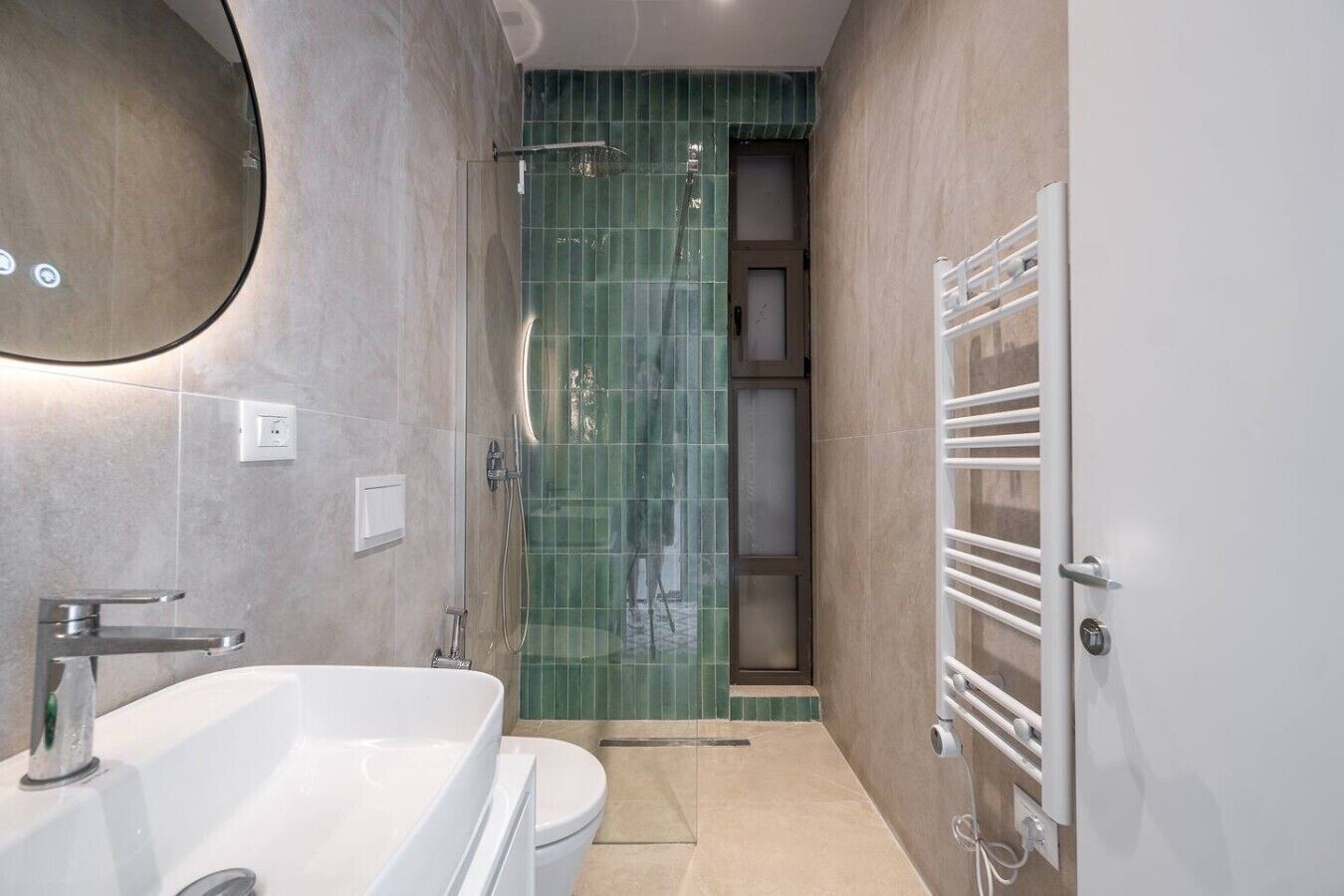Une salle de bain moderne équipée d’une baignoire, de toilettes et d’un espace douche.