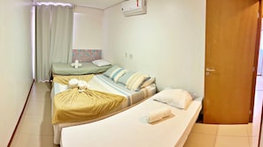 A room with two beds, a curtain, a wall-mounted air conditioner, and a door. - MF102 | 3-bedroom, 3-bathroom apartment near Ponta Verde beach (Maceió)
