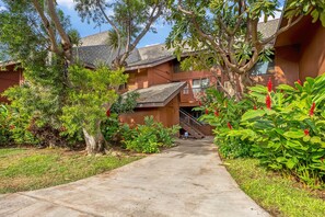 A pathway leading to a building with a tiled roof and multiple windows. - Koa Resort 3E | Two Bedroom Condo in Kihei (Kihei)