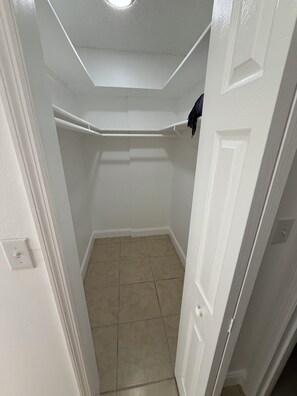 A narrow hallway with a white door on the right, a white wall, and a tiled floor. - Peaceful 2/2 in Homosassa Springs Hot Spot (Homosassa Springs)