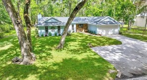 A two-story house with a garage, surrounded by a well-maintained lawn and trees.