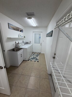 A compact kitchen with a sink, countertop, and a door leading to another room. - Peaceful 2/2 in Homosassa Springs Hot Spot (Homosassa Springs)