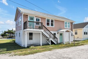 A two-story house with a front porch, a staircase leading to the upper floor, and a small attached garage. - 27 Steps to Beach and BOOM you’re there + Secret Game Room + Rooftop Deck (Carolina Beach)