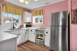 A kitchen with white cabinets, a stainless steel refrigerator, a microwave, and an oven. - 27 Steps to Beach and BOOM you’re there + Secret Game Room + Rooftop Deck (Carolina Beach)