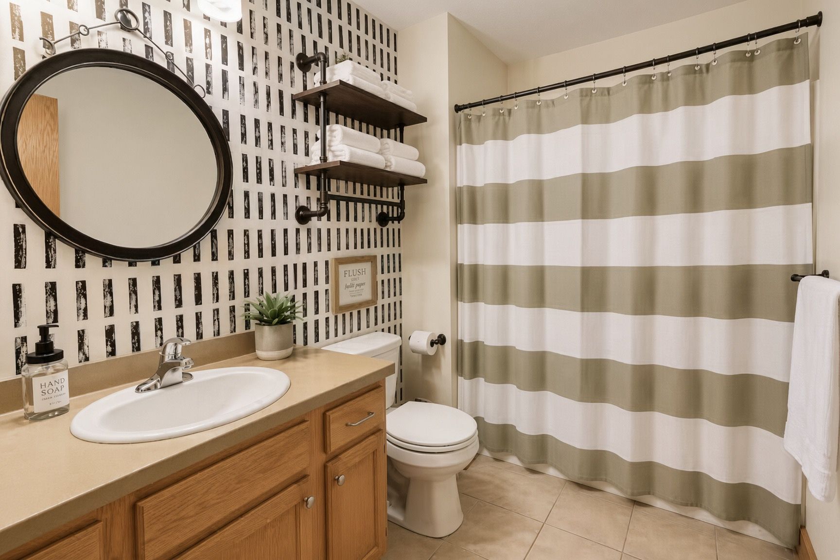 A bathroom with a round mirror, a sink, a toilet, a shower curtain, and a towel rack.