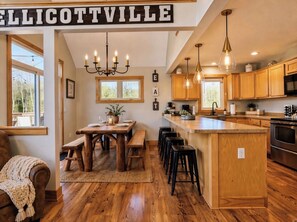 Cocina amplia con gabinetes de madera, una isla central e iluminación colgante.