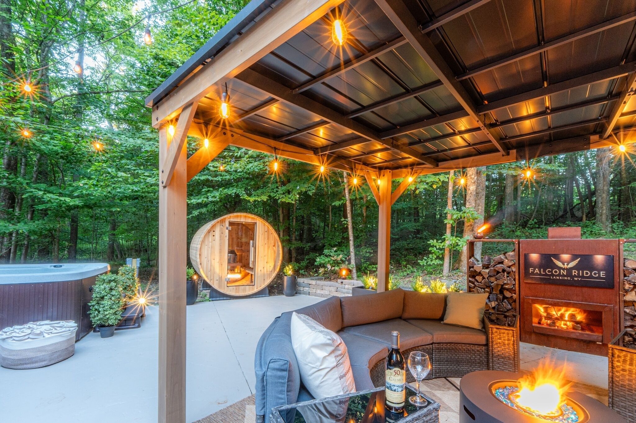 Un espace extérieur accueillant avec des sièges confortables, un jacuzzi, une structure en bois et un foyer.