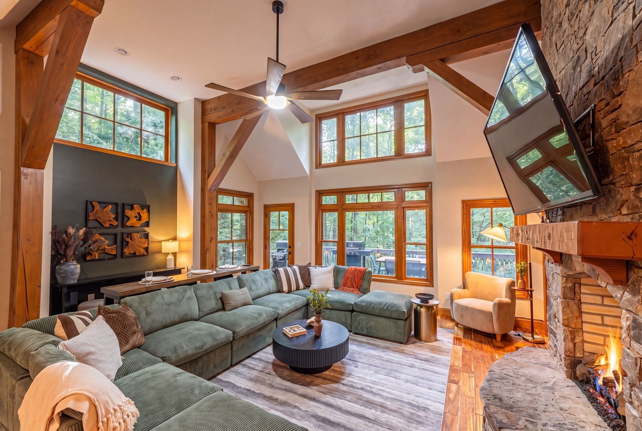 A spacious living room with a sectional sofa, a fireplace, and large windows.