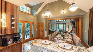 A spacious dining area with a long table set for a meal, wooden cabinetry, and a coffee station.