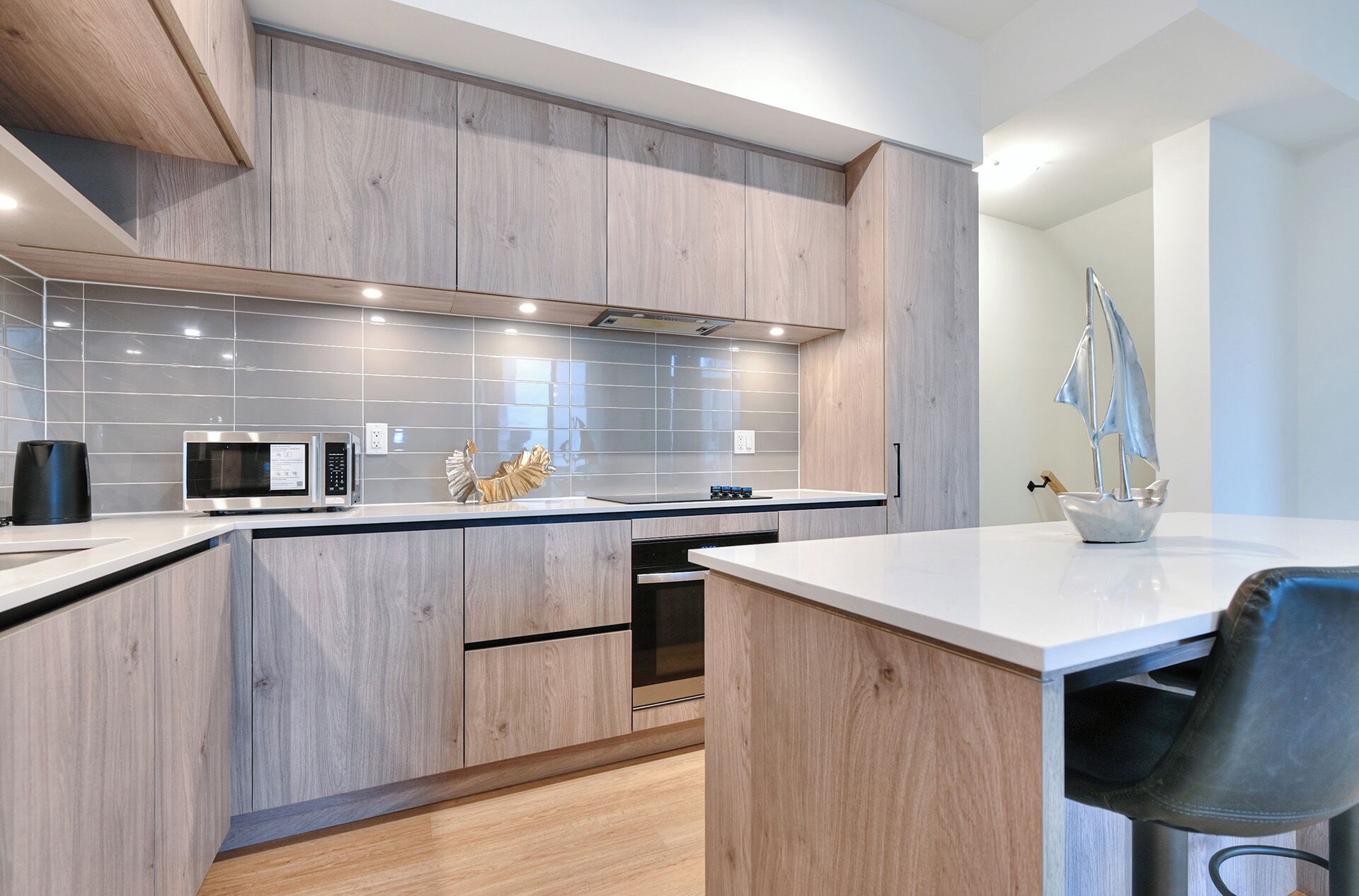 Een moderne keuken met houten kastjes, een magnetron en een spoelbak.