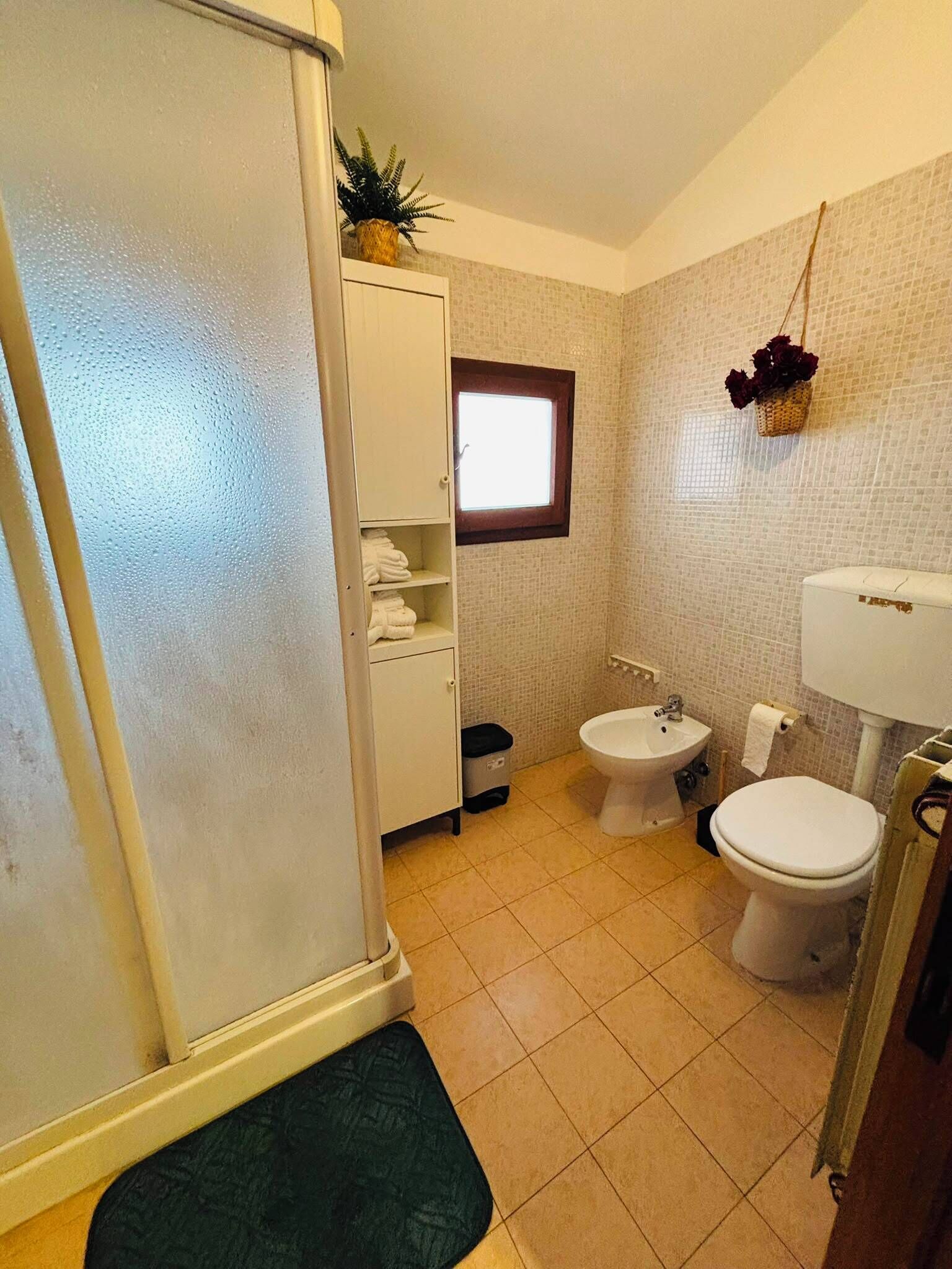 A bathroom with a toilet, bidet, and a white sink.