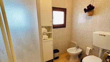A bathroom with a toilet, bidet, and a white sink.