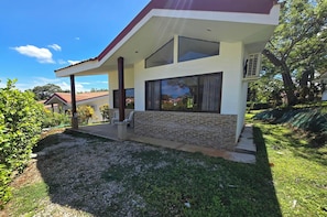 A modern house with a covered porch, stone facade, and large windows. - Casa Loma - 3 piscinas near the beach Jungle villa (Venado)