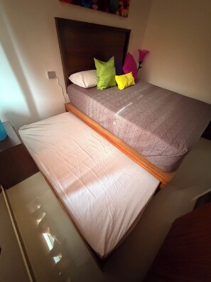 A bed with a headboard, multiple pillows, and a mattress that can be adjusted.
