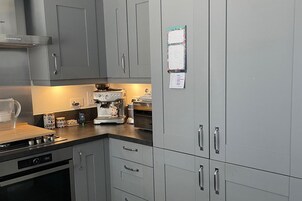 Una cocina moderna con armarios grises, una cafetera y un hervidor.
