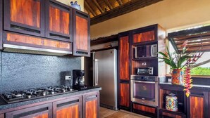 Una cocina con gabinetes de madera, una estufa a gas, un microondas y un horno.
