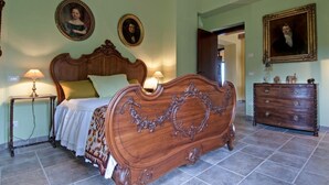 Una camera da letto con un letto grande, due comodini, una cassettiera e due quadri appesi al muro.