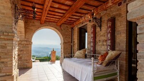 Un letto con vista sulle montagne, un arco in pietra e un soffitto in legno.