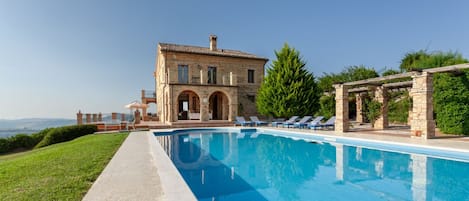 A swimming pool with a stone building in the background.