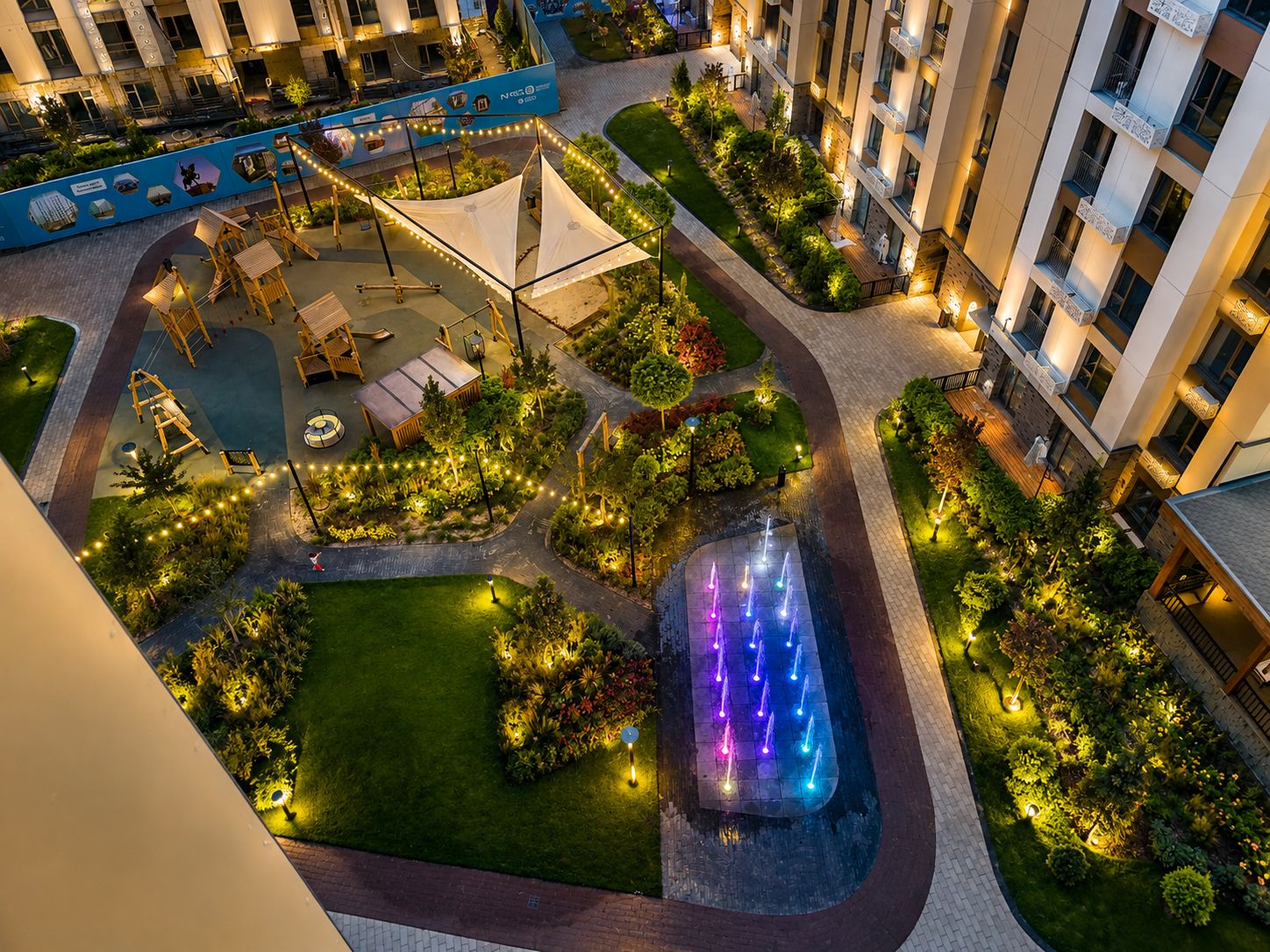 A hotel courtyard with outdoor seating, a water feature, and well-maintained landscaping.