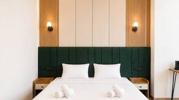 Une chambre d’hôtel avec un grand lit, deux tables de chevet et une tête de lit ornée de panneaux de bois verticaux.