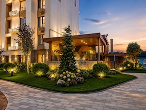 A hotel with a modern design, featuring a covered outdoor area with seating and a staircase leading to the upper floors. - Noor Hotel by Byond (Tashkent)