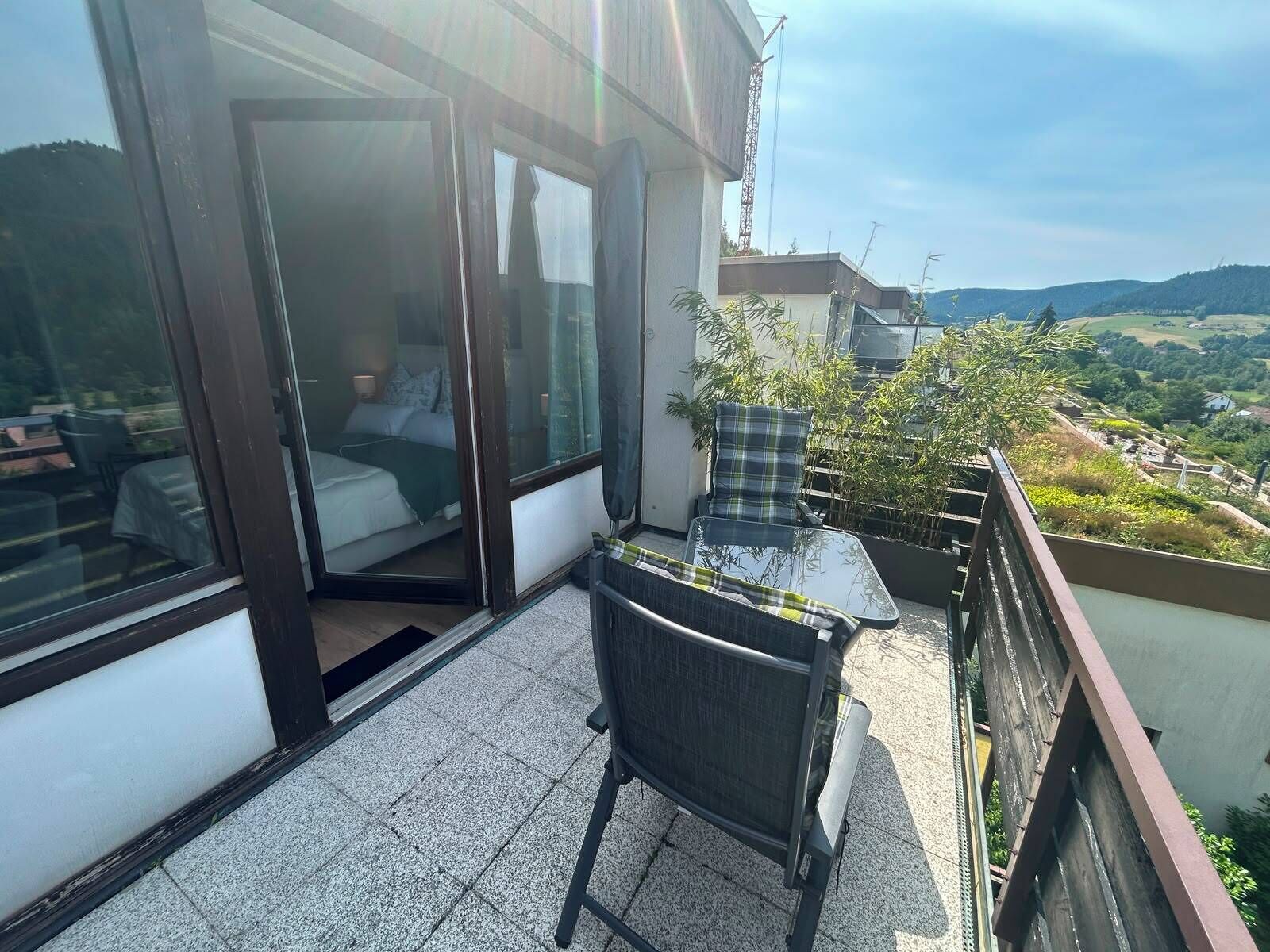 Ein Balkon mit einem Bett, einem Sessel und einem Tisch.