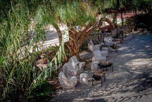 Un jardín con mobiliario exterior y un muro de piedra.