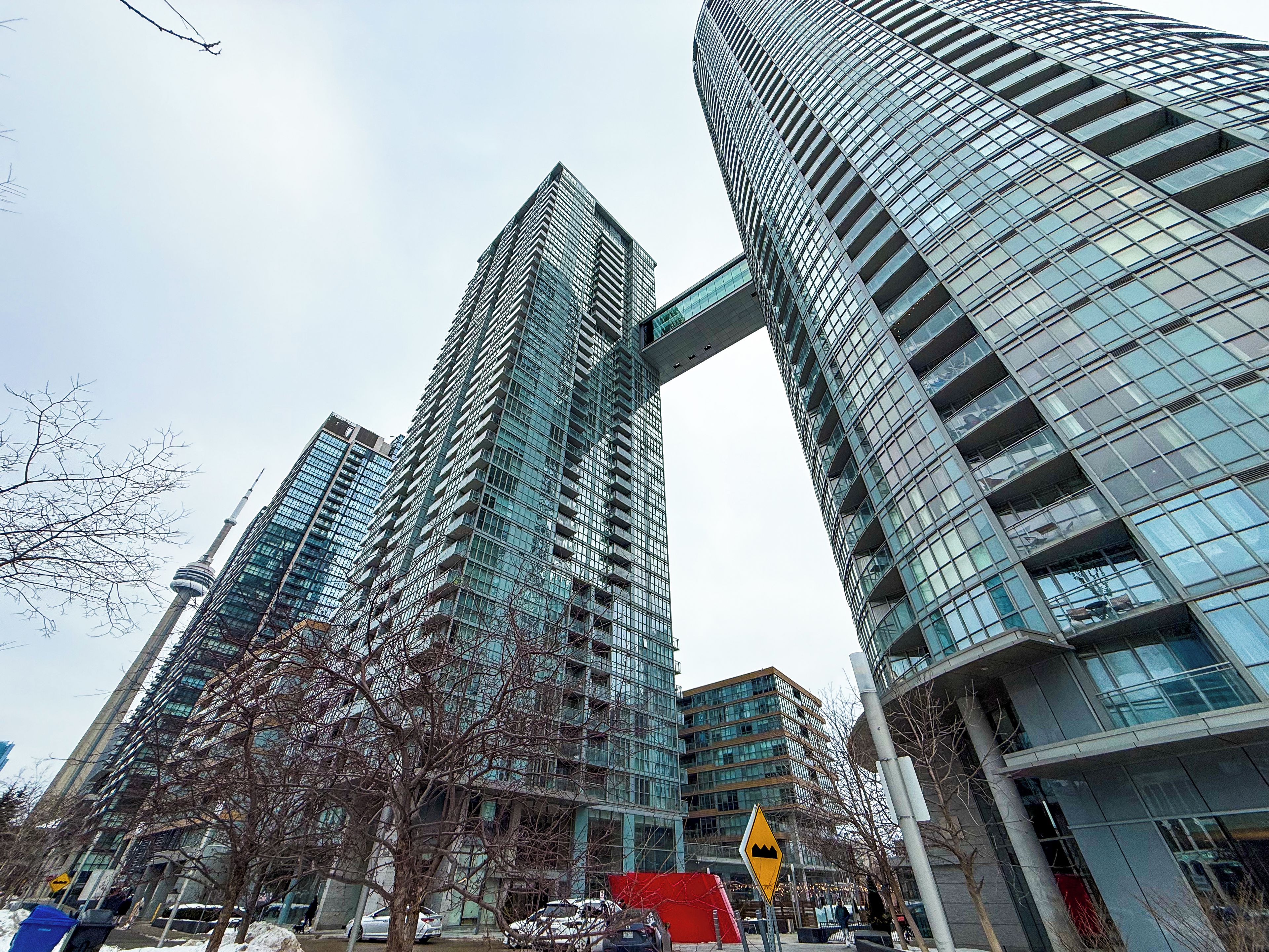 A modern urban skyline with high-rise buildings, including a distinctive curved structure.