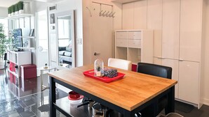 A modern kitchen with a wooden table, black chairs, and white cabinets. - City Central Residences Downtown Toronto (Toronto)