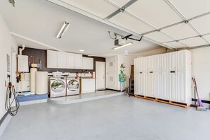 A spacious laundry room with a large washing machine, dryer, and a water heater. - Private Backyard Oasis-Pool/Bocci/Golf (Palm Springs)