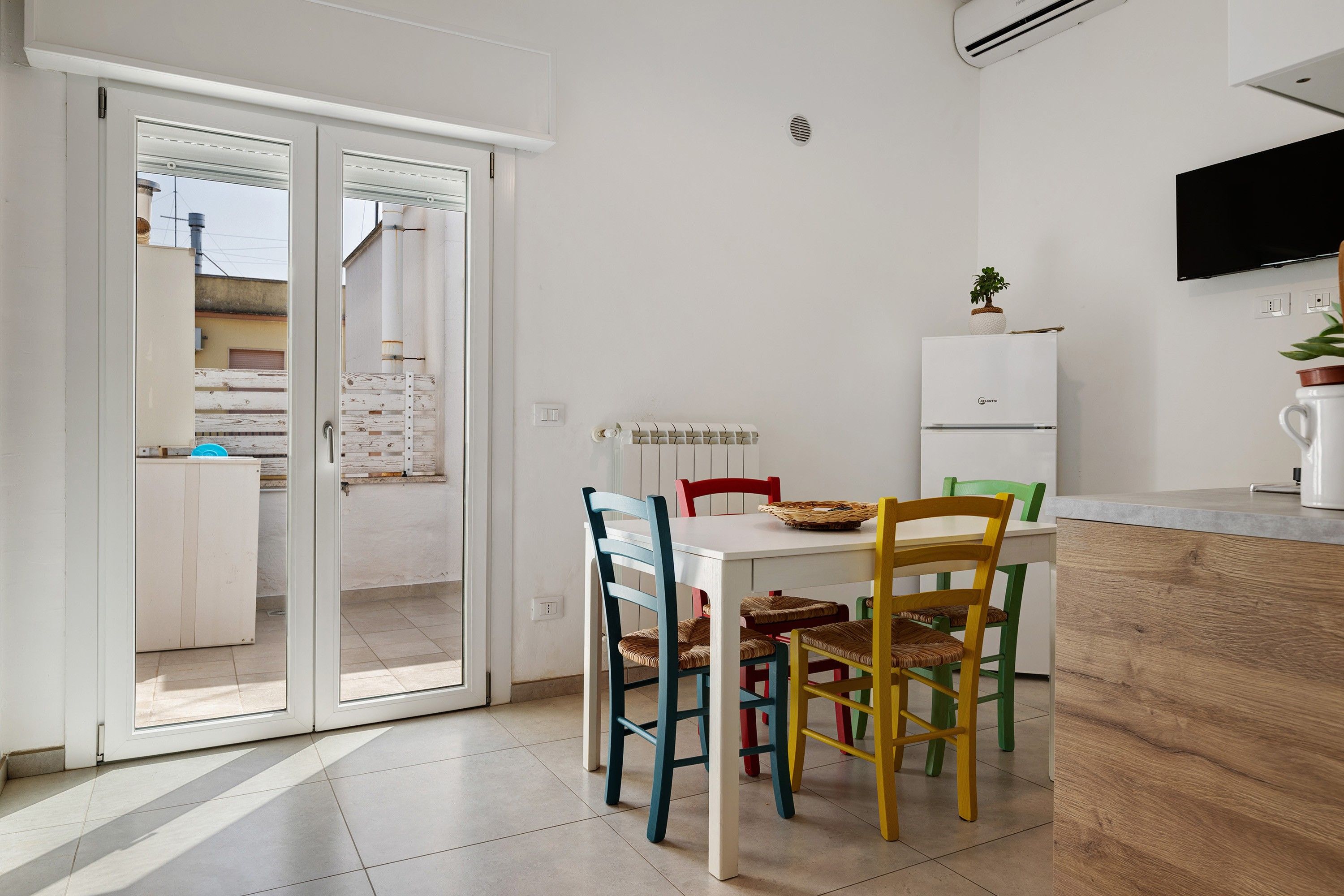 A modern kitchen with a white countertop, a built-in oven, and a small refrigerator.
