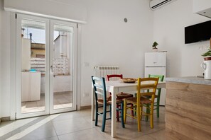 Una cucina moderna con piano di lavoro bianco, forno integrato e piccolo frigorifero.