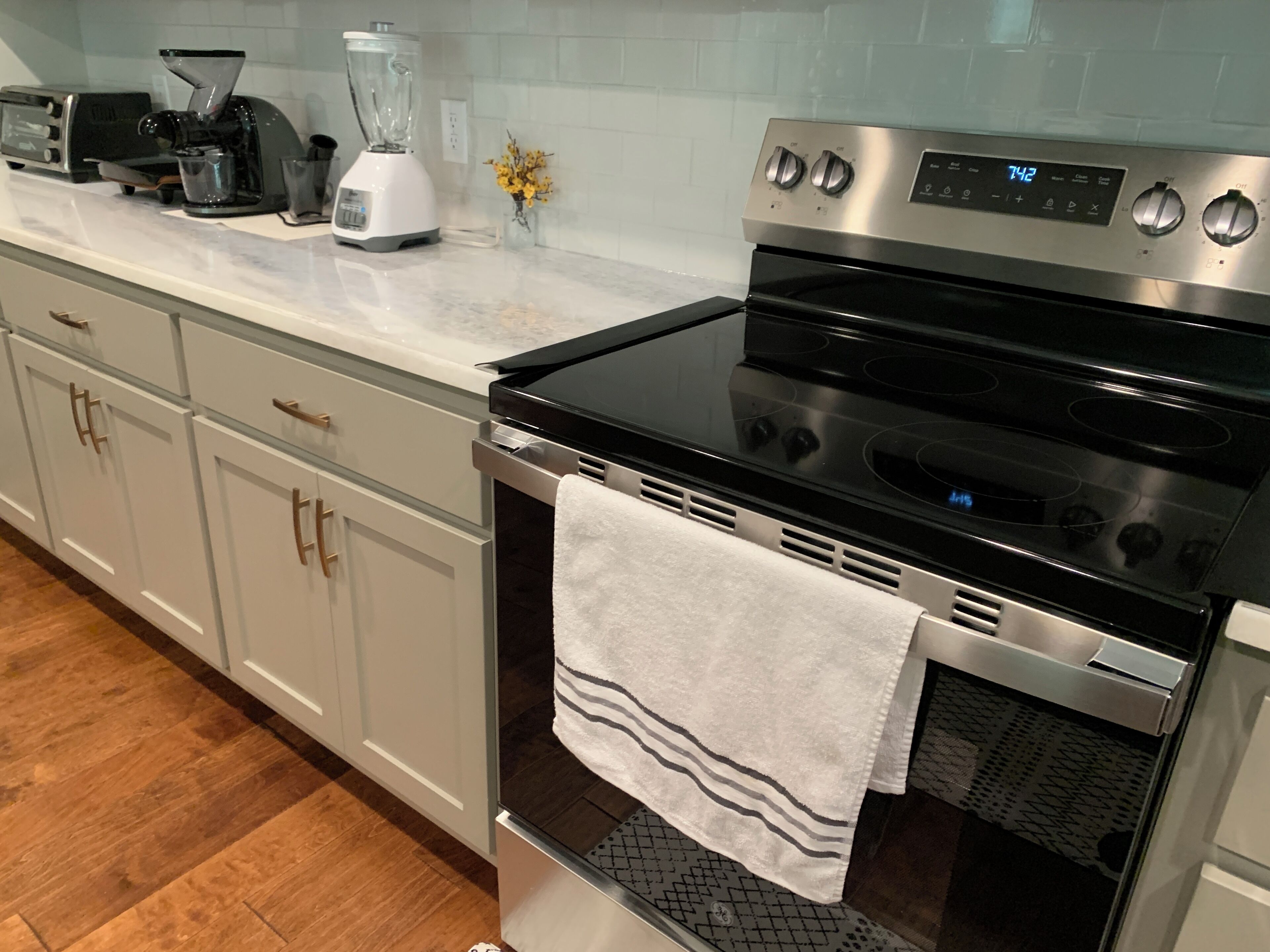 A kitchen with a stainless steel oven, a built-in microwave, and a coffee maker on the countertop.