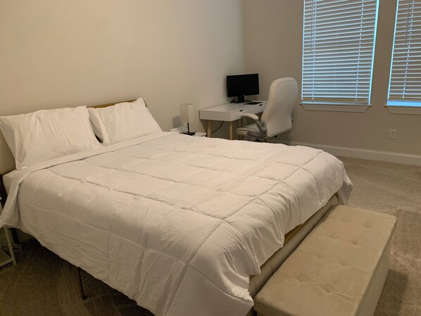 A bedroom with a large bed, a desk with a computer, and a window with blinds. - Cozy Southern Retreat 3 (Oxford)
