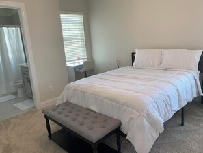 A bedroom with a bed, a bench, a desk, and a window. - Cozy Southern Retreat 3 (Oxford)