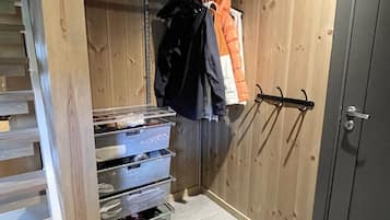 Una habitación funcional con armario, perchero y cajones.