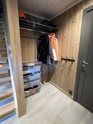 Une pièce de taille modeste, équipée d’une armoire, d’un portant à vêtements et de tiroirs de rangement.