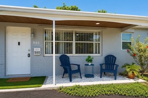 A house with a white door, two blue chairs, a small table, and a potted plant. - Comfy Home 4 Beds Steps to Hard Rock Stadium Free Parking Miami Gardens (Miami)