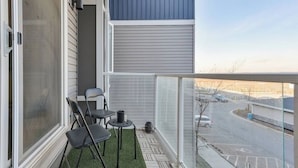 Un balcon donnant sur un parking et une rue.