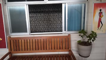 Un banco de madera frente a una ventana con diseño floral.