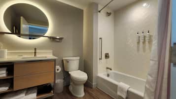 A modern bathroom with a toilet, sink, vanity, and a walk-in shower.