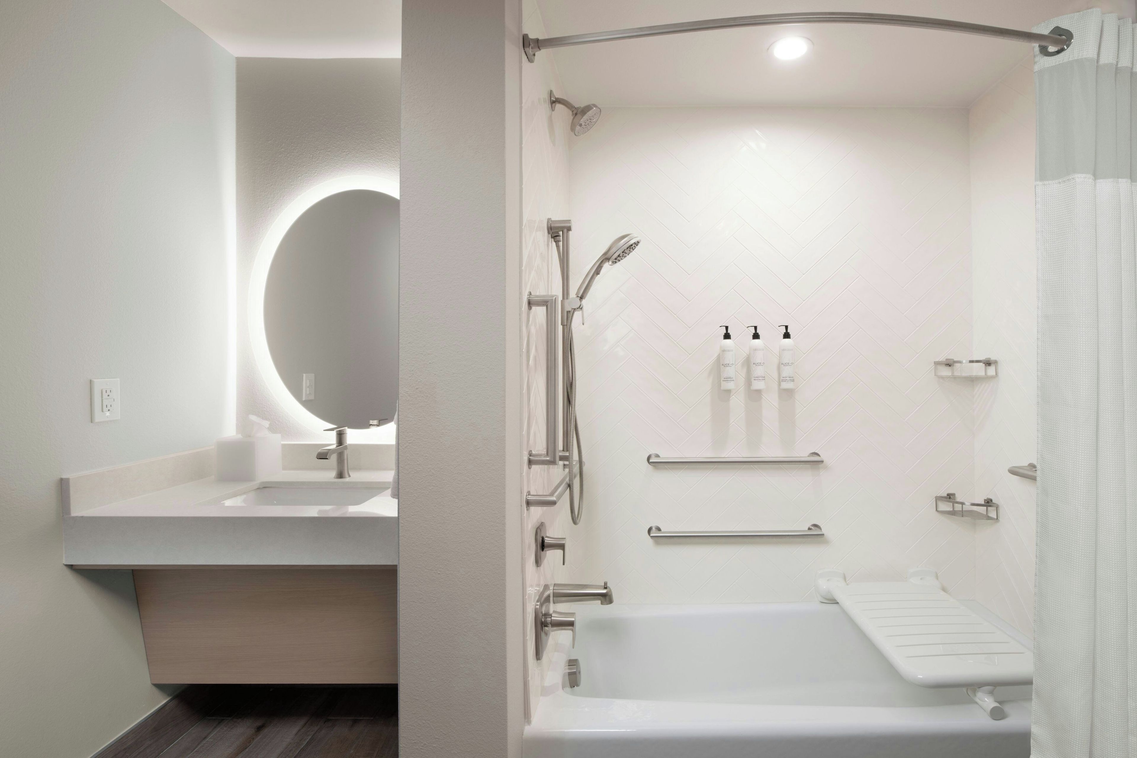 Ein modernes Badezimmer mit Badewanne, Dusche und einem Waschbecken mit Spiegel.