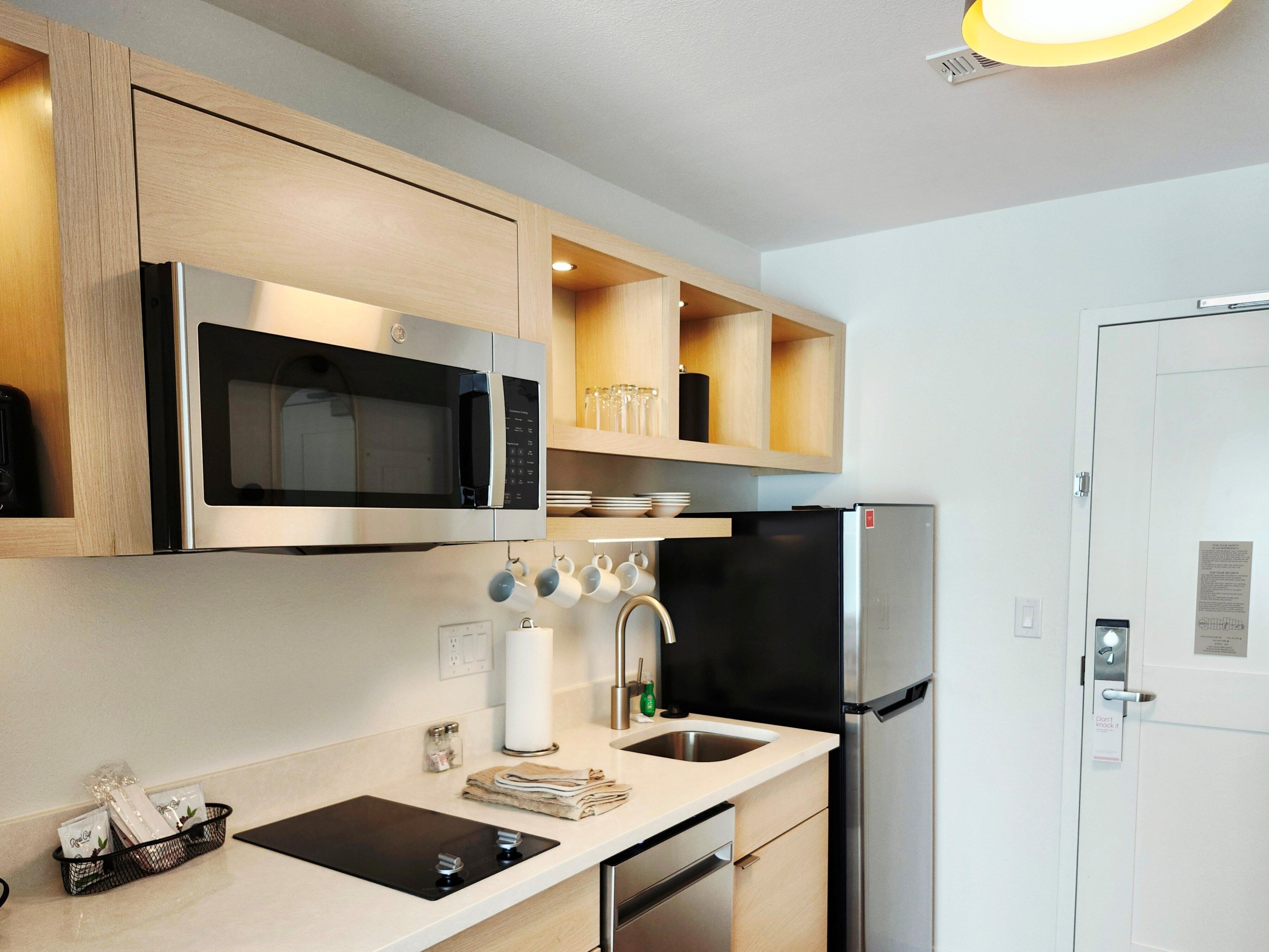 A modern kitchen with stainless steel appliances, wooden cabinets, and a built-in oven.
