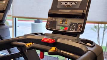 A treadmill with a digital display, control panel, and safety features.