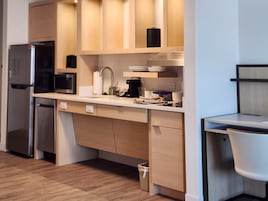 Una cocina moderna con refrigerador, microondas y cafetera incorporados.