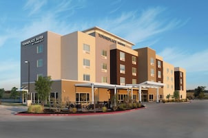 Un hotel Towneplace Suites by Marriott con un diseño moderno, varios pisos y un área exterior techada.