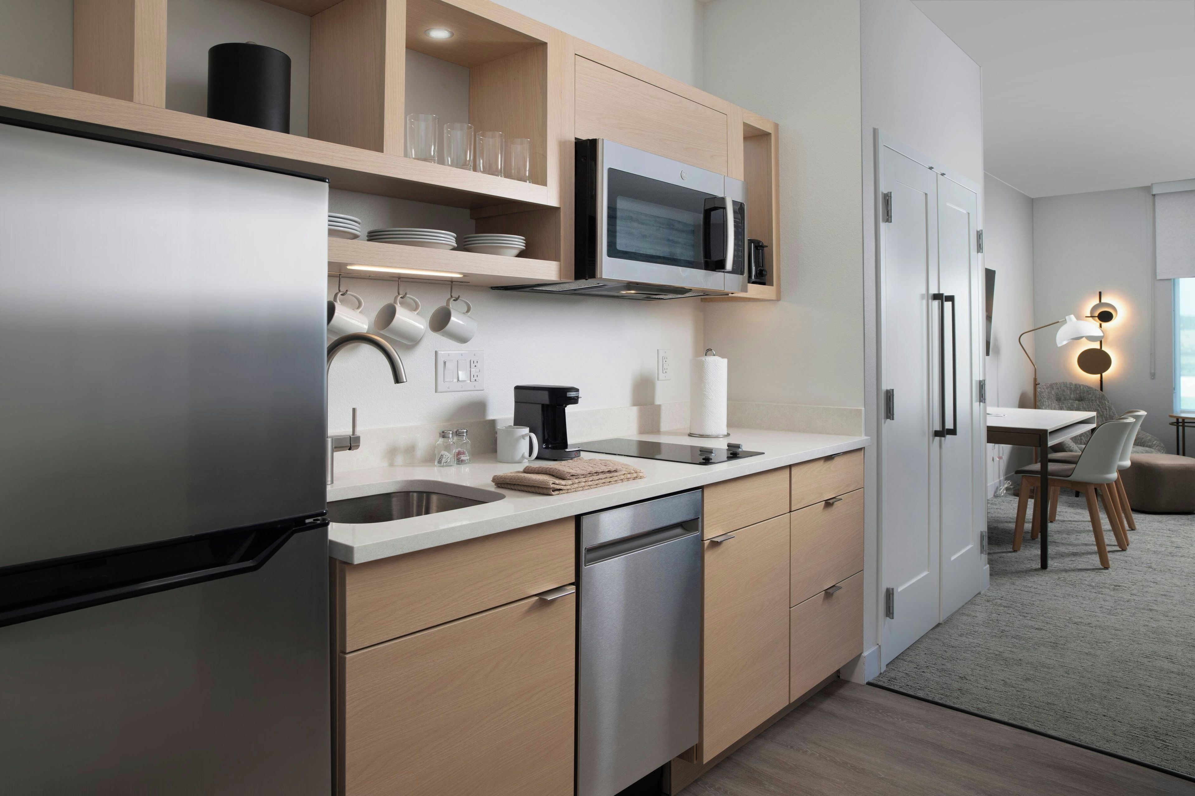 A modern kitchen with a stainless steel refrigerator, a microwave, and a coffee maker.